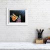 Framed painting of a painted lady butterfly hanging on a wall.