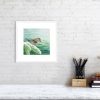 Goldcrest print in a white frame hanging on a wall.