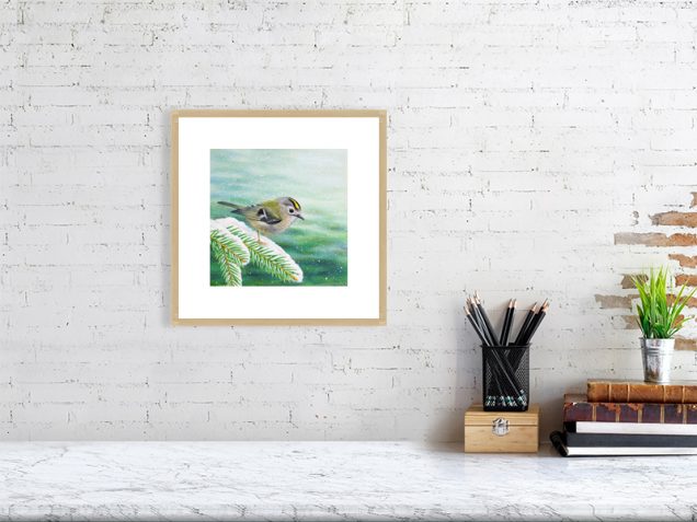 Goldcrest print in an oak frame hanging on a wall.